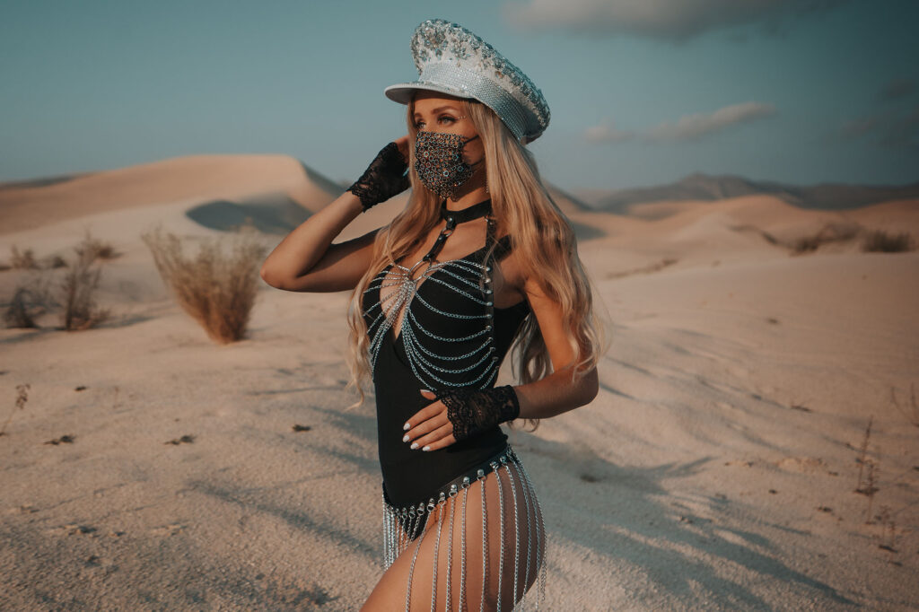 Model in a sequin hat and fringe outfit in the desert dunes — Burning Man series