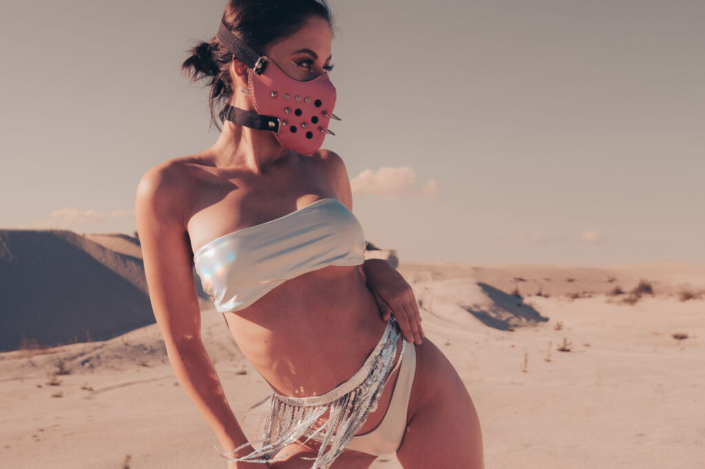 Valerie posing in a Burning Man inspired scene with a bold, artistic, and sensual atmosphere.