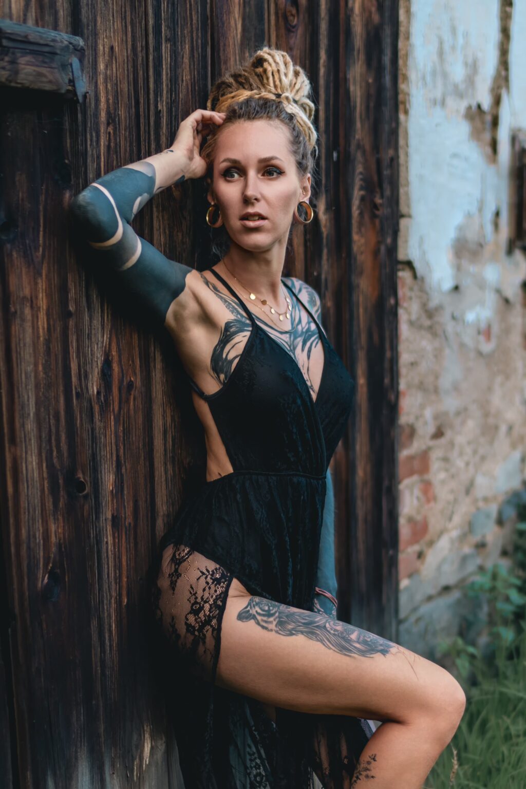 Naira.Sax posing among summer flowers and grass with an abandoned mill in the background.
