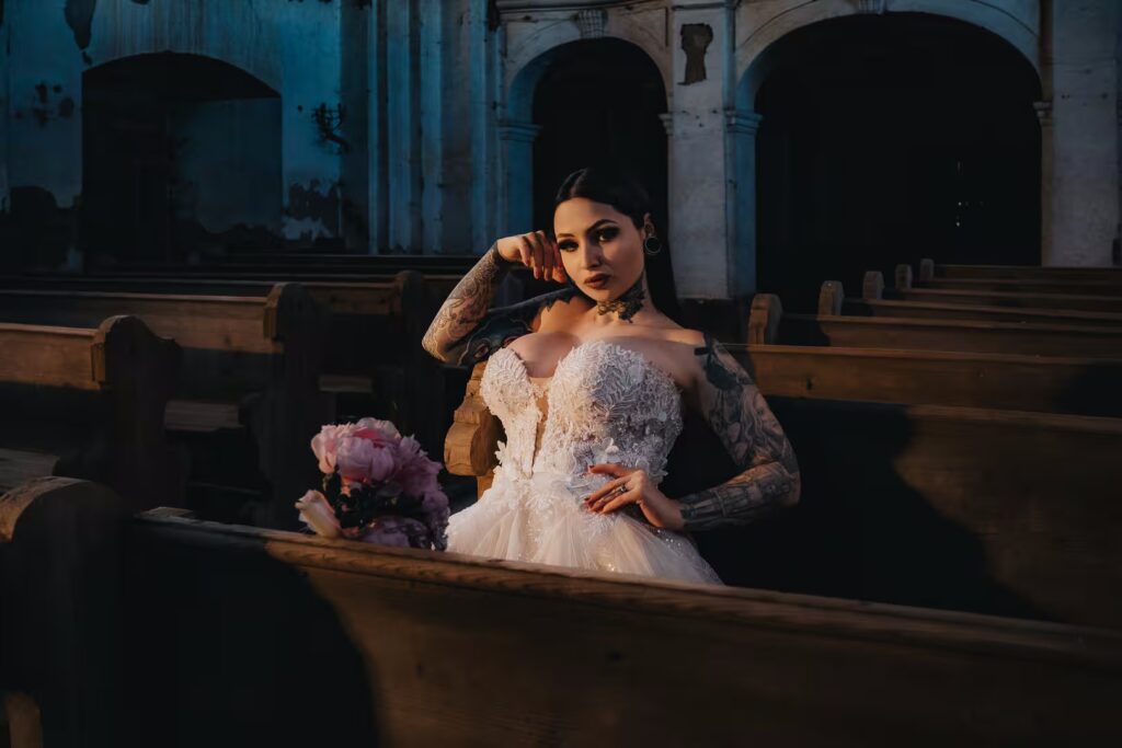 Tereza in a wedding dress holding a bouquet among church pews