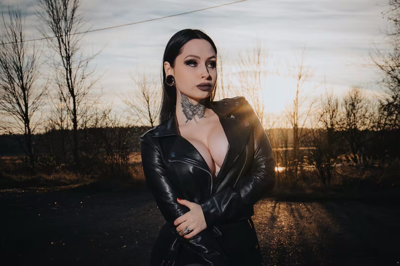 Tereza in a black leather jacket in a forest clearing at sunset