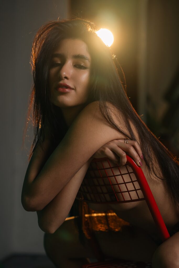 Sofia in a black lace top in warm evening light in a Prague studio
