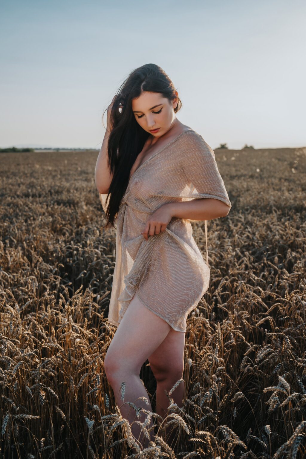 Nikol in a summer dress in the wheat at sunset