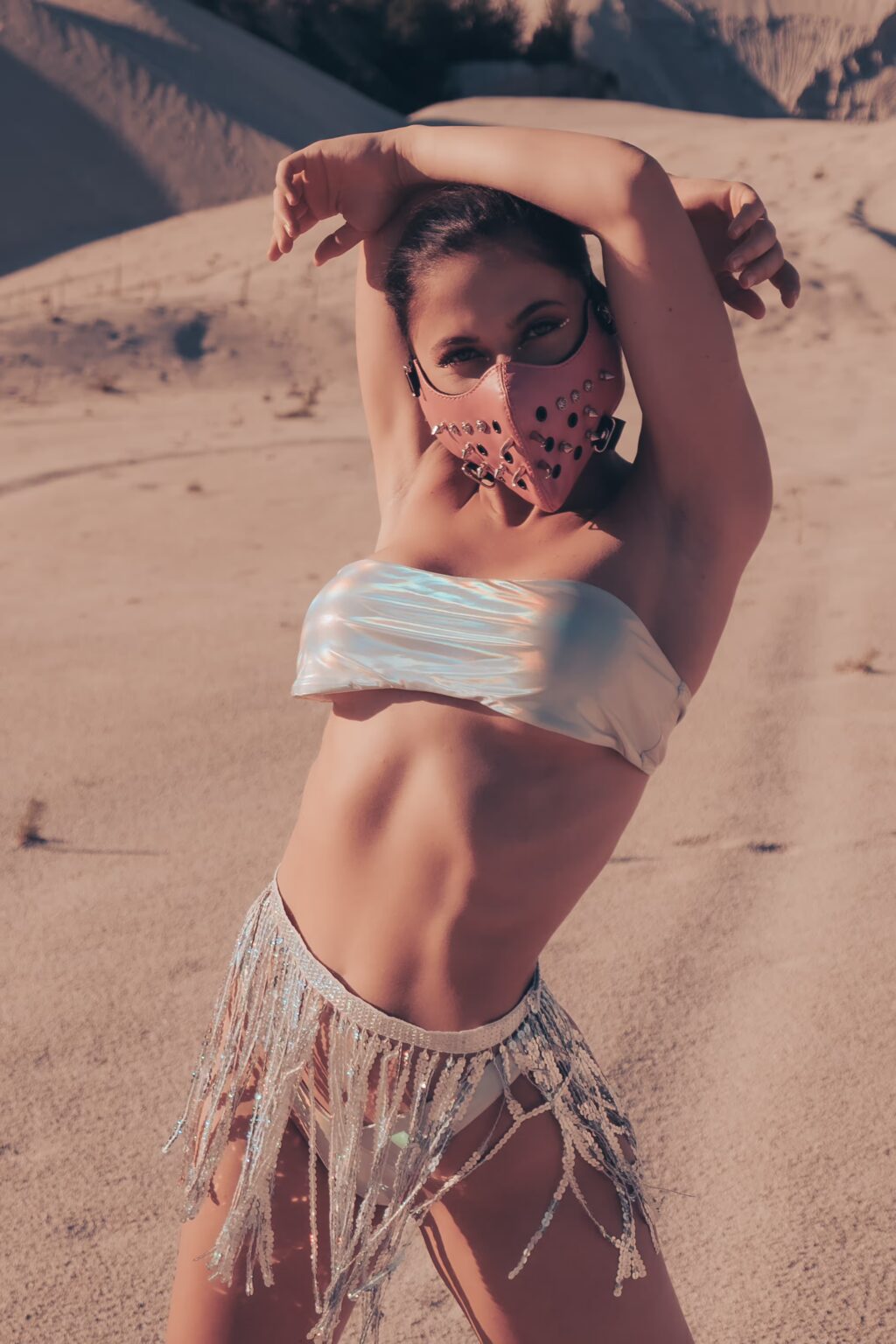 Valerie wearing a Burning Man inspired outfit surrounded by desert sand