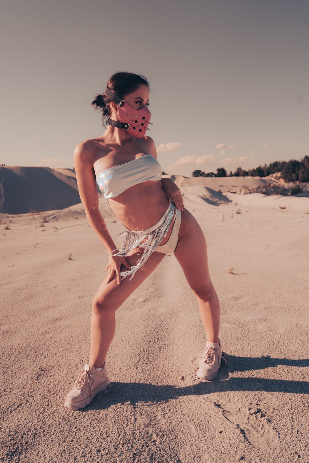 Valerie posing in a silver outfit during a Burning Man photoshoot in the desert