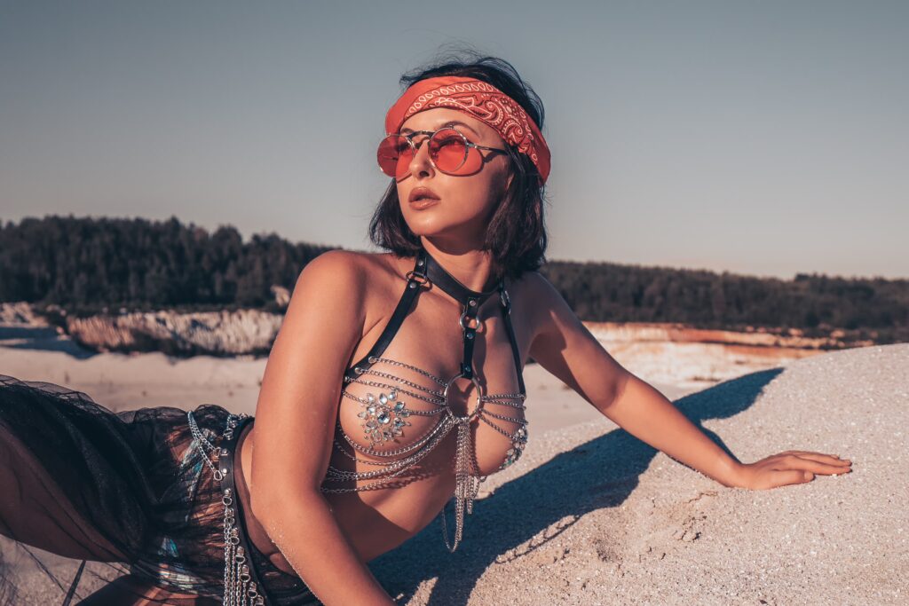 Valerie posing on desert sand in a Burning Man style costume