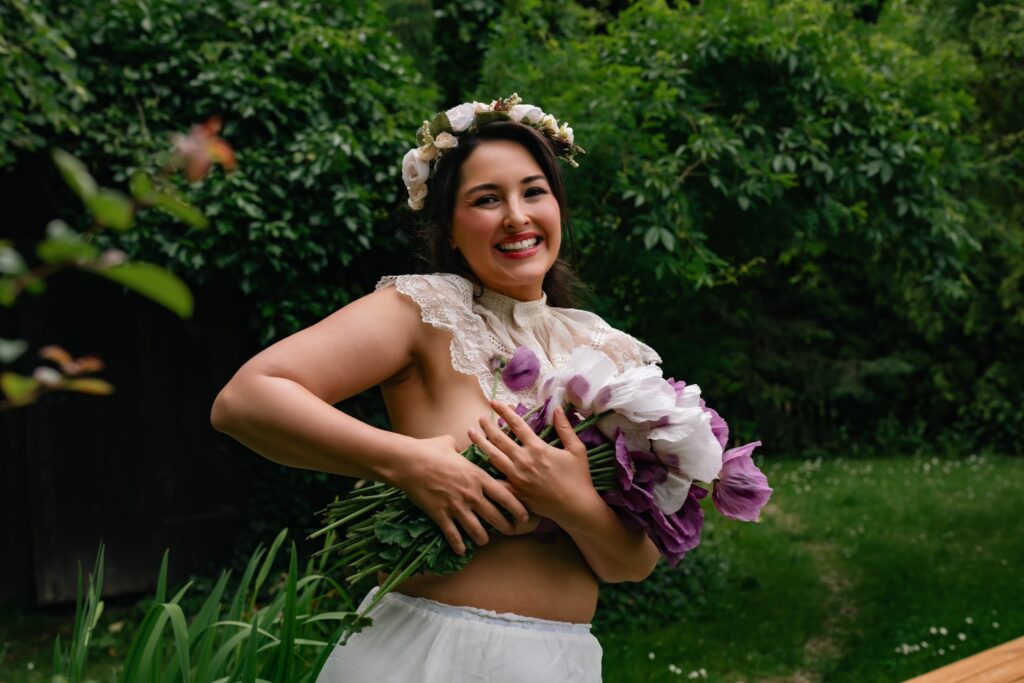 A young woman posing in a garden with a bouquet of tulips during a HotFolk photoshoot.