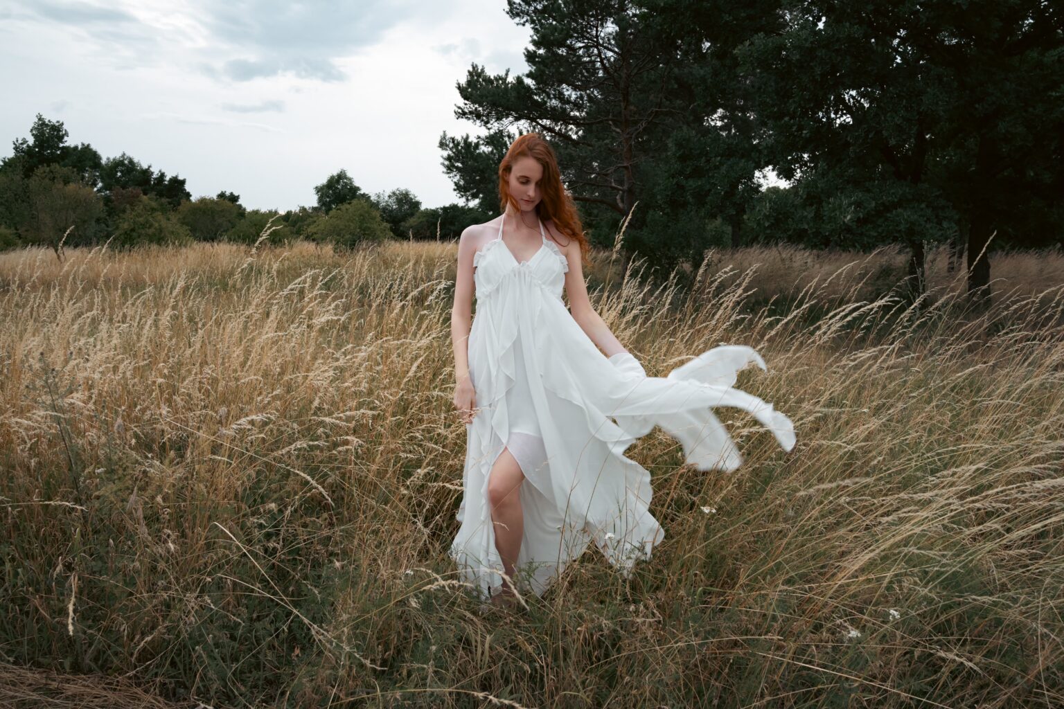 Kuro Rain in a white dress walking through a flower meadow