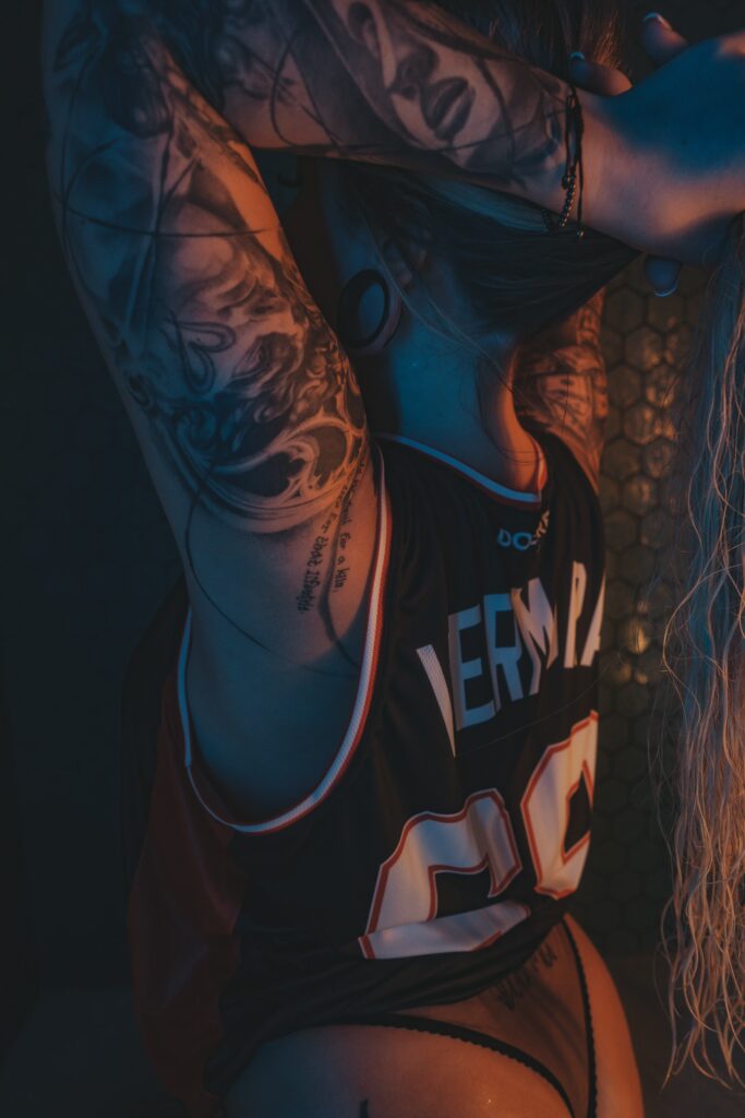 Vermora wearing a wet sports jersey during a shower photoshoot