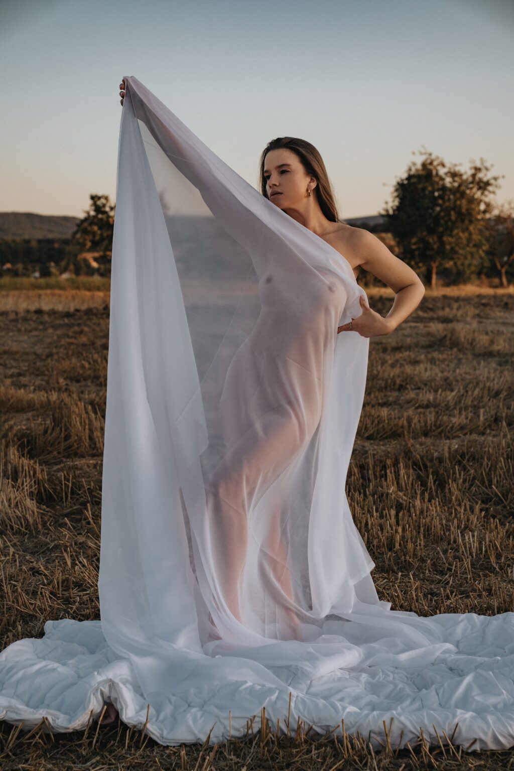 Won't Tell You holding a white fabric in the wind in a field