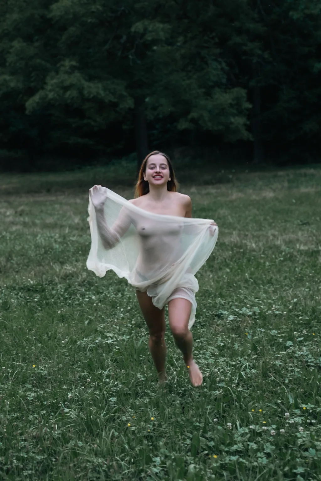 Mellisa running through a park with a white veil