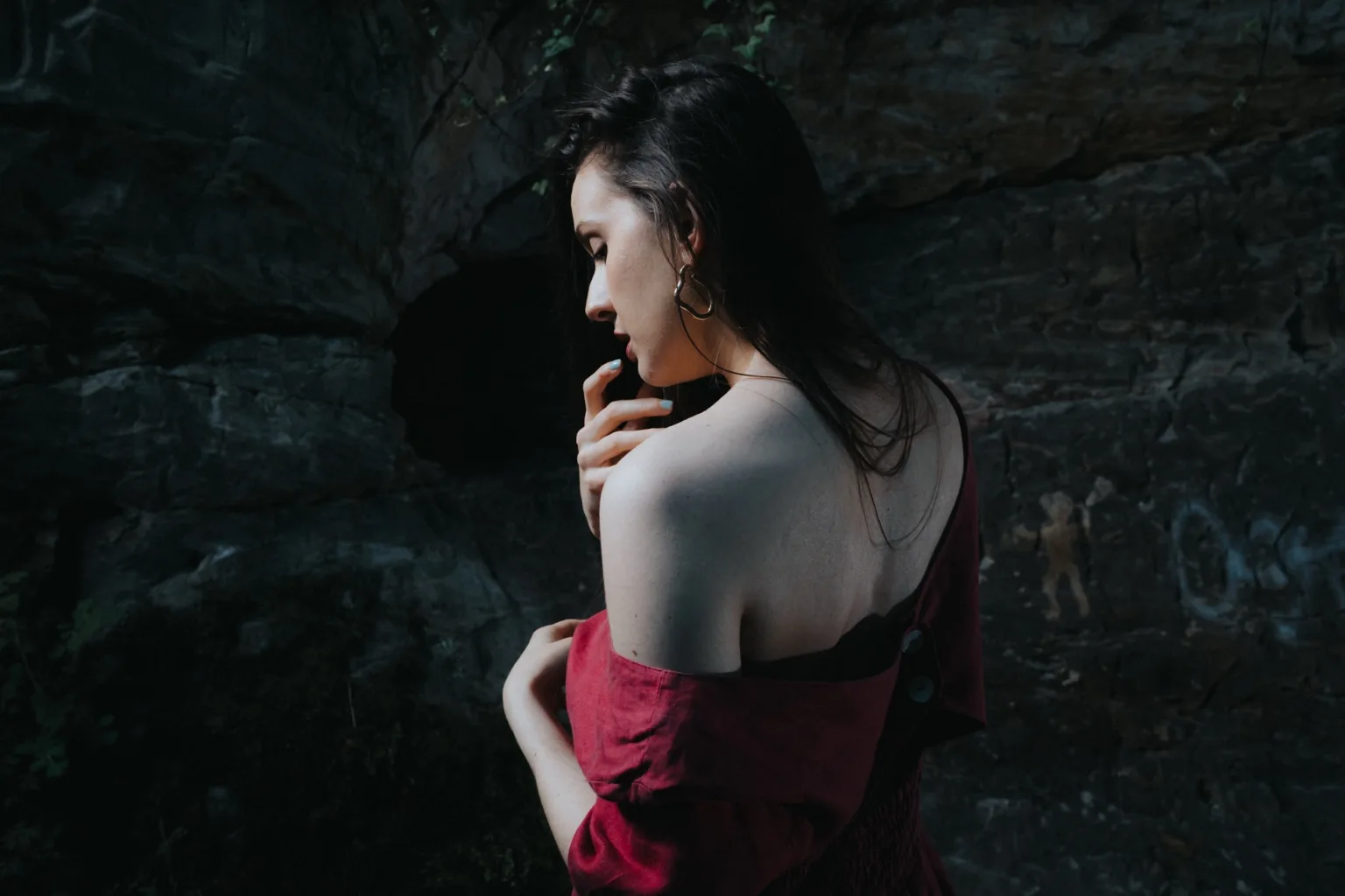Anna in a pink dress with bare shoulders in a dark room