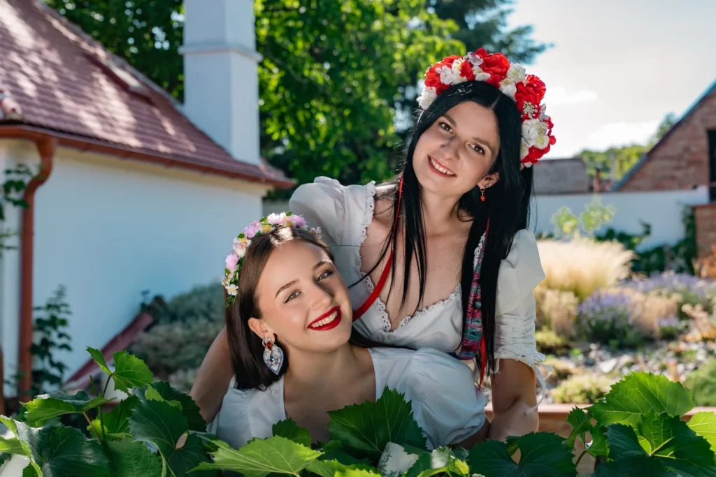 Two models in white blouses and flower crowns at a Moravian farmstead, HotFolk 2027 calendar