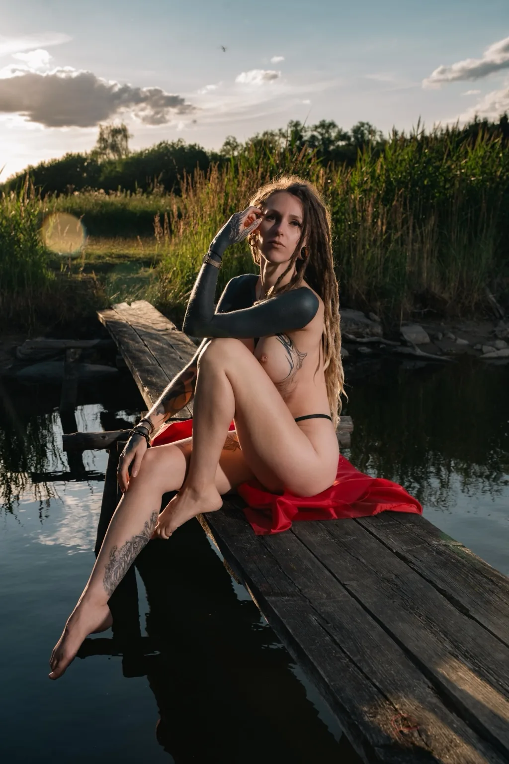 Naira Sax with red fabric sitting on a wooden jetty